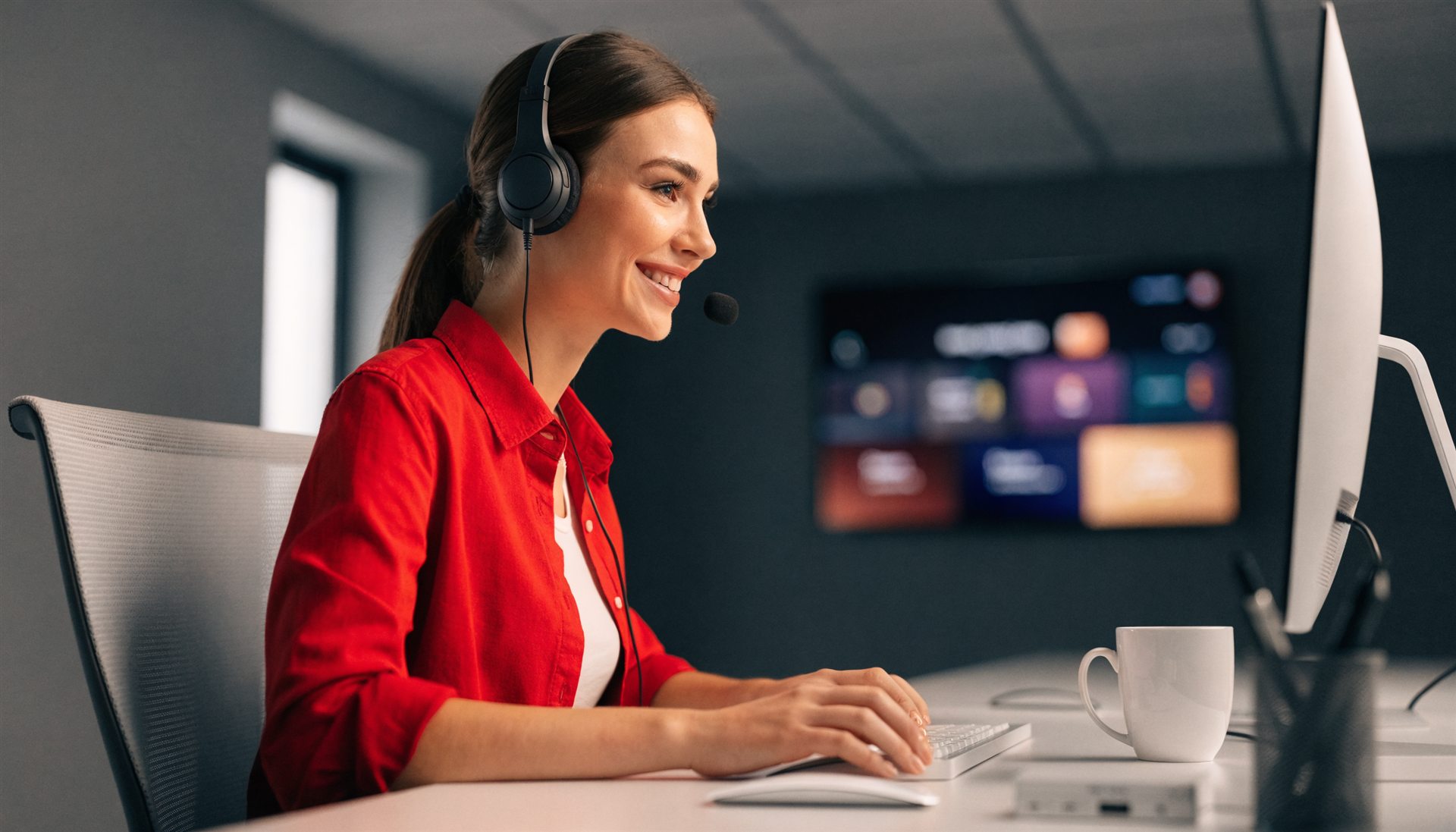 Freundlicher Kundensupport mit Headset am modernen Arbeitsplatz